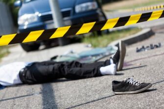 Person laying on the ground after a pedestrian accident with a car